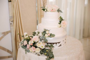 Çiçeklerle süslenmiş güzel düğün pastası