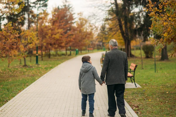 Opa und Enkel gehen im Park spazieren. die Zeit miteinander verbringen — Stockfoto