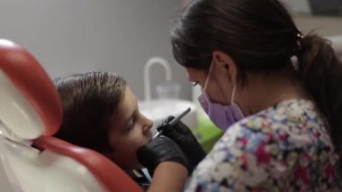 Bir çocuk diş hekimi ziyaret, bir kadın doktor Childs'ın diş davranır