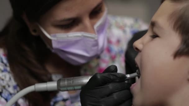 Lékařství, zubní lékařství a zdravotnictví koncepce - zubař s kid pacienta na zubní klinice nastavení židle — Stock video