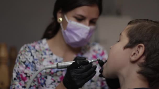 Medicina, odontologia e conceito de saúde dentista feminino com paciente criança na clínica odontológica ajustando cadeira — Vídeo de Stock