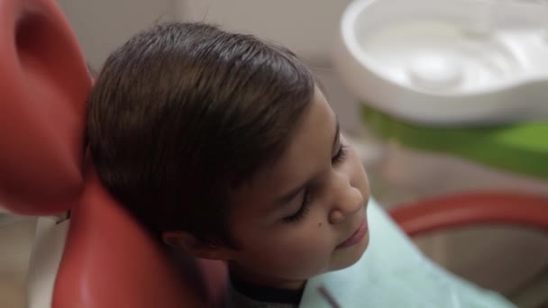 Niño en el dentista sentarse en la silla con la boca abierta — Vídeo de stock