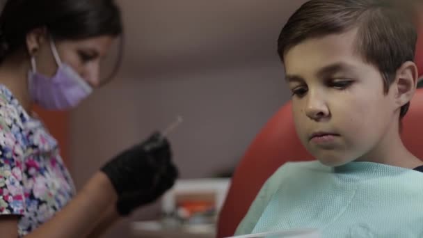 Dentista no trabalho. Paciente menino na clínica odontológica — Vídeo de Stock