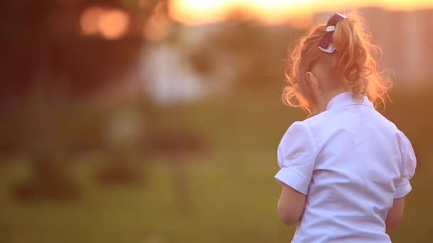Kleine jongen en meisje rennen en spelen. Ze blazen de paardebloem. zonsondergang — Stockvideo
