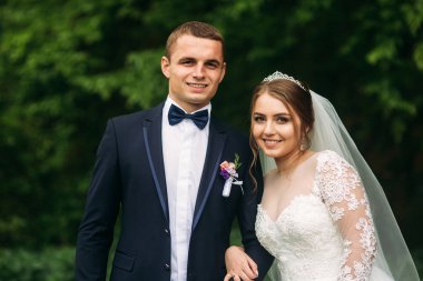 Yeni evliler düğün gününde parkta yürüyorlar. Gelin ve düğün gününde Enjoying damat