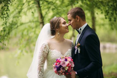 Yeni evliler düğün gününde parkta yürüyorlar. Gelin ve düğün gününde Enjoying damat