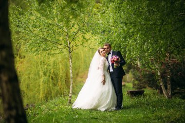 Yeni evliler düğün gününde parkta yürüyorlar. Gelin ve düğün gününde Enjoying damat
