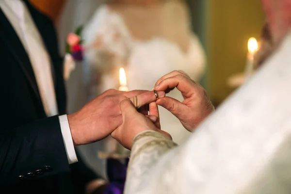 A noiva e o noivo fazem um voto de amor na igreja. usando um anel — Fotografia de Stock