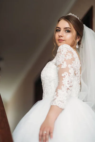 Linda novia vestida en casa en un vestido de novia —  Fotos de Stock