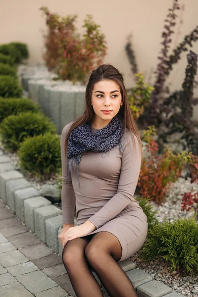 Bayan kaldırım kenarında oturur ve fotoğrafçı için poz veriyor. Sonbahar photosession — Stok fotoğraf