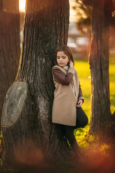 Kleines Mädchen im Herbstmantel posiert für Fotografen. Goldener Herbst — Stockfoto