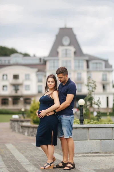 Schwangere und ihr Ehemann umarmen sich und lächeln — Stockfoto