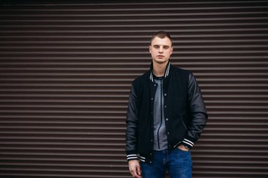 Bir arka plan koyu çizgili duvar siyah ceketli genç bir çocuk