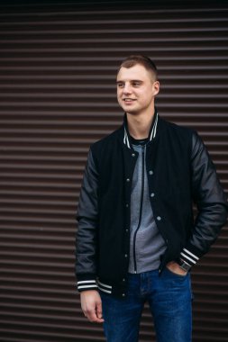 Bir arka plan koyu çizgili duvar siyah ceketli genç bir çocuk