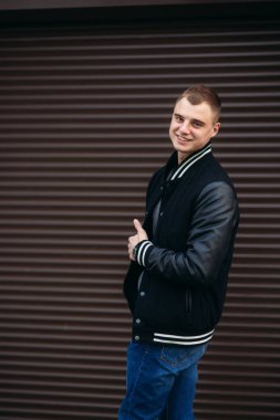 Bir arka plan koyu çizgili duvar siyah ceketli genç bir çocuk