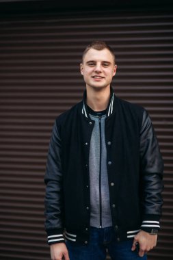 Bir arka plan koyu çizgili duvar siyah ceketli genç bir çocuk