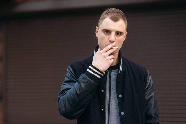 Bir arka plan koyu çizgili duvar siyah ceketli genç bir çocuk