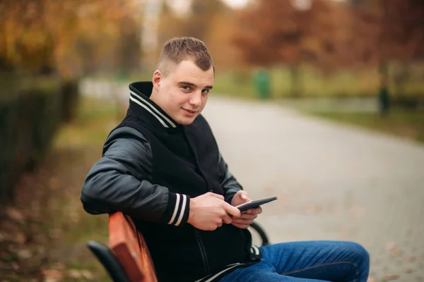 Молодий хлопець у чорній куртці використовує планшет — стокове фото