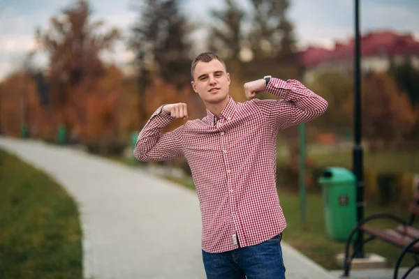 Junger Mann im roten Hemd bleibt im Park — Stockfoto