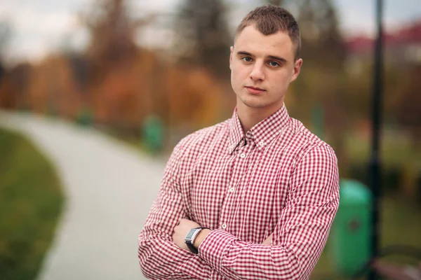 Junger Mann im roten Hemd bleibt im Park — Stockfoto