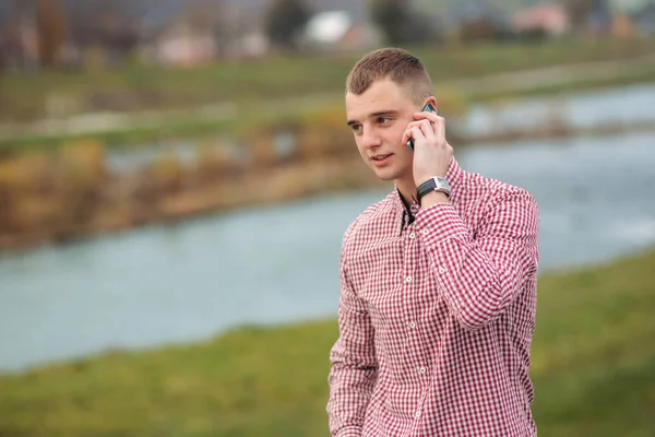 Стильний хлопець у сорочці, що розшукується, використовуючи телефон — стокове фото