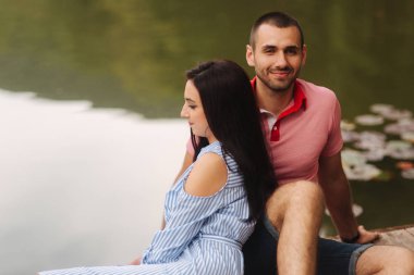 Bir adam ve bir kız romantik bir atmosferde, iskele oturur hoşlanıyoruz