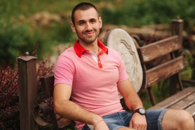 Adam banch ve gülümseme üzerinde oturur. Mutlu insanlar