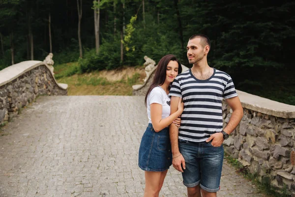 Ungt par i kärlek umgås tillsammans nära den stora gamla bron — Stockfoto