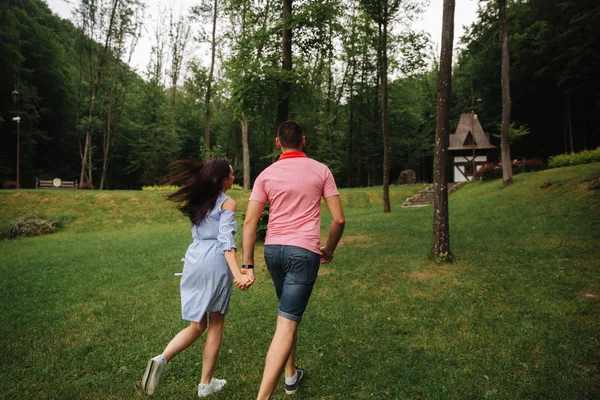 Couple se tient les mains et courir — Photo