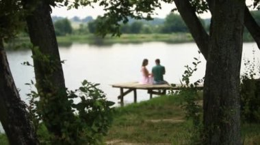 İskeleye yakın göl güzel youn çift otur. Romantik bir atmosfer. Arka biew