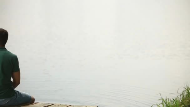 Belo casal youn sentar-se no cais perto do lago. Ambiente romântico — Vídeo de Stock