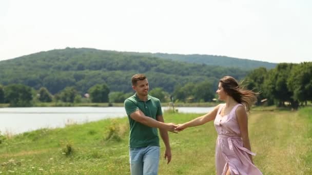 Mädchen geht mit Kerl und führt ihn. Romantische Atmosphäre — Stockvideo