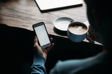 Telefonunuzun ve bir kafe içinde kahve yudumlarken öğrenci