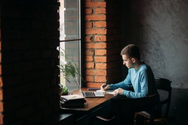 Öğrenci çalışma ve bir şey not defterinde bir kafe ve yazma kahve içme. Bir sınav için hazırlanın