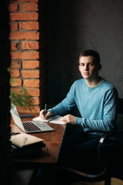 Öğrenci çalışma ve bir şey not defterinde bir kafe ve yazma kahve içme. Bir sınav için hazırlanın