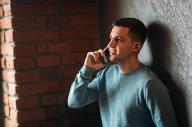 Erkek bir kafede telefonuyla pencerenin dimdik. Evet