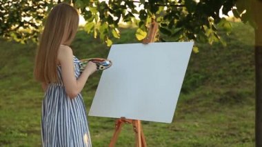 Güzel kız sanatçı parkta duran ve palet boya ile tutarak