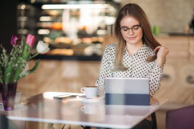 Genç kız programer kafede dizüstü bilgisayar ve telefon kullanın. çalışma öğrenci