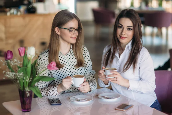 Девушки используют перерыв с работы, чтобы выпить кофе и поболтать — стоковое фото