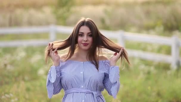 Vista de cerca de la hermosa mujer embarazada en vestido azul caminando escuchar la granja. Sonríe y feliz cámara lenta — Vídeo de stock