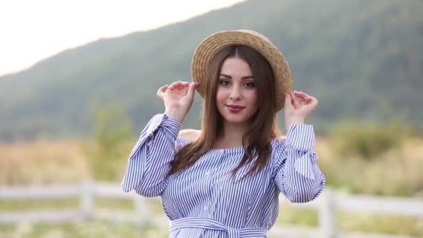 Mulher grávida em vestido azul e chapéu de malha posa para câmera — Vídeo de Stock