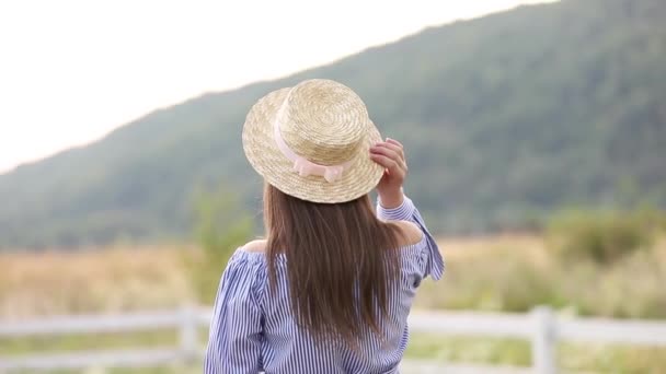 Vista trasera de la dama de sombrero. Fondo de las montañas — Vídeos de Stock