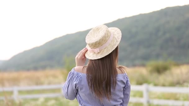 Vista trasera de la dama de sombrero. Fondo de las montañas — Vídeos de Stock