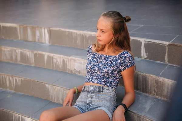 Dospívající žena na sobě džíny sedí na schodech — Stock fotografie