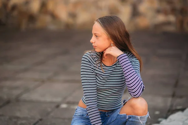 Jonge tiener poses aan fotograaf. blond meisje in spijkerbroek en blouse — Stockfoto