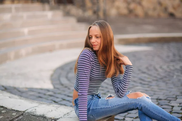 Jonge tiener houdingen voor foto. blond meisje in spijkerbroek en blouse — Stockfoto