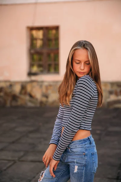 Junge Teenager posieren für Fotos. Blondes Mädchen in Jeans und Bluse — Stockfoto
