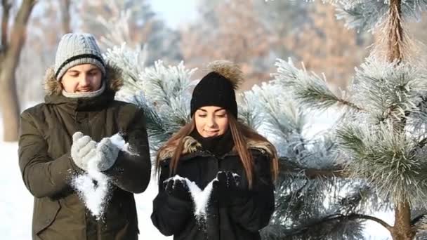 Una pareja amorosa en el clima invernal de cuento de hadas juega bolas de nieve. cámara lenta — Vídeos de Stock