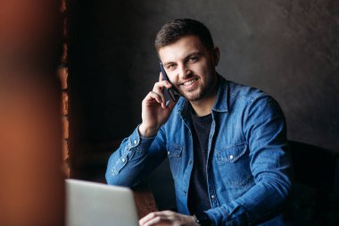 O bir dizüstü bilgisayar kullanırken arama kafede alarak genç işadamı