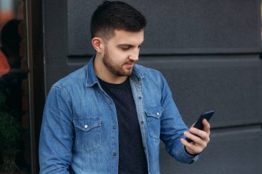 Çekici bir genç adam sokakta telefon kullanma